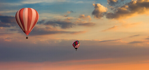 Colorful hot air balloons flying on the sunset sky background.