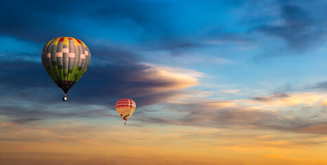 Colorful hot air balloons flying on the sunset sky background.