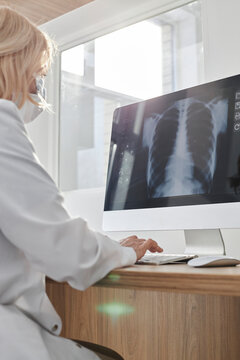 Doctor using desktop PC looking at X-ray image in clinic