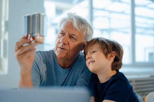 Senior man with grandson analyzing heating module at home