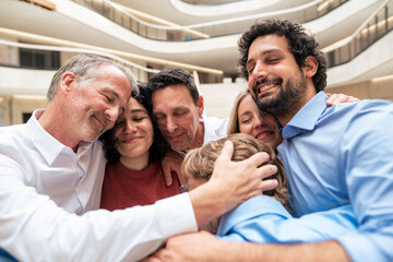 Happy business colleagues embracing each other at office
