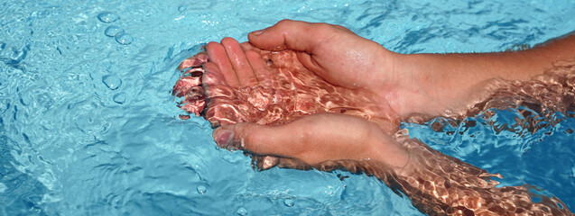Banner the hands cupped together submerged in clean clear blue water in swimming pool