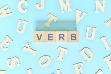 Verb concept in English grammar and learning class lesson. Wooden blocks typography word flat lay...