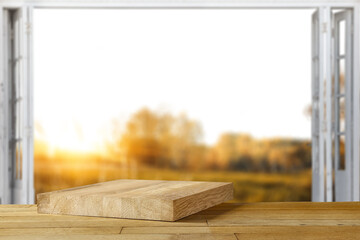 Wooden desk of free space and autmn window background. 