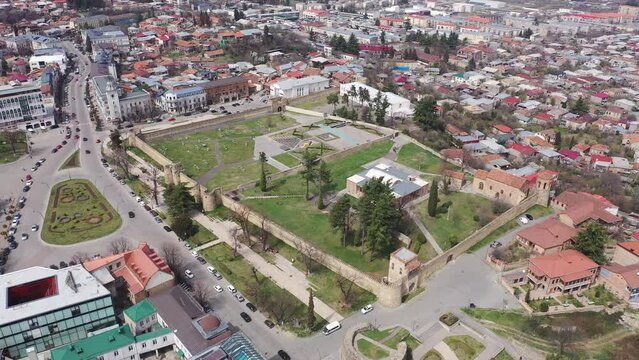 Scenic view from drone of central areas of Telavi city overlooking medieval walled Batonis Tsikhe fortress on spring day, Georgia
