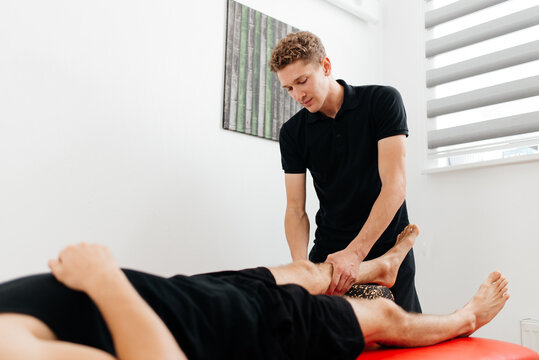 Cropped image of a physiotherapist massaging and kneading a patient's leg provides medical care for sprained ligaments. Concept of rehabilitation and recovery after physical leg injuries.