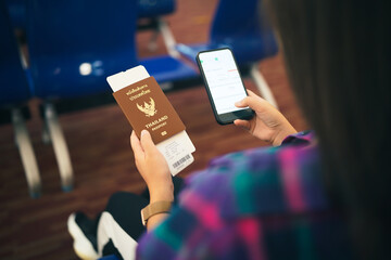 Woman waiting for departure at the airport on your vacation hold passport and smartphone while...