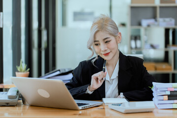 Friendly cheerful asian businesswoman smiling, people emotions and casual concept, positive woman working in office workspace.