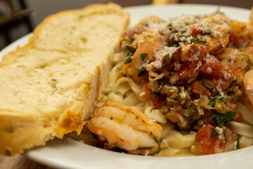Shrimp Fra Diavolo Topped with Shaved Asiago Cheese served with  a slice of Asiago Cheese Bread 
