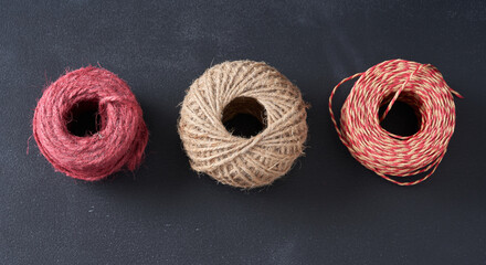 A tangle of multi-colored threads on a dark background.