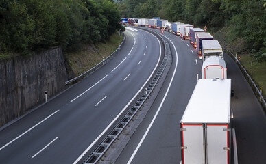 stack of trucks in a long traffic jam on the freeway