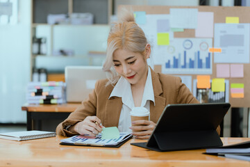 Businesswoman working with calculator and laptop computer at office workplace, finance marketing chart, Business digital technology and marketing concept.