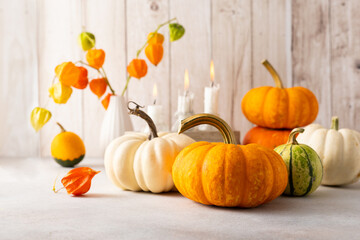 Autumn still life with pumpkins, flowers and candles on table.Thanksgiving day or halloween concept.