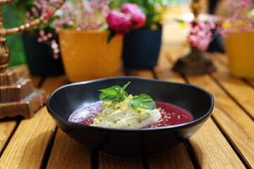 Dessert with forest fruit mousse, garnished with pistachio powder and mint leaves, selective focus.