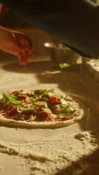 Vertical Screen: Restaurant Professional Chef Preparing Pizza, Adding Sauce, Traditional Family Recipe. Authentic Sunny Pizzeria, Cooking Delicious Food. Slow Motion Cinematic Focus on Hands Shot