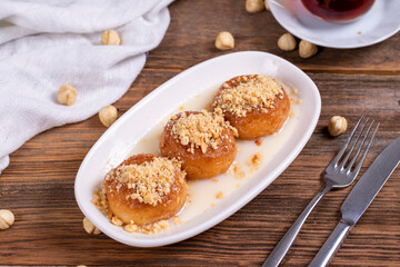 Milky kemalpasa dessert. Dessert with milk and hazelnuts on wooden background. Traditional Turkish cuisine. Close-up. local name sutlu kemalpasa tatlisi