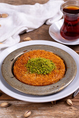 Kunefe. Traditional Turkish cuisine. Kunefe with pistachio on wooden background. close up