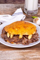 Meat between bread rolls. Meat doner in fat bread on wooden background. Traditional Turkish cuisine. Close-up. local name tombik et doner