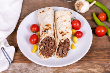 Wrap Doner Kebab. Meat doner kebab on wooden background. Traditional Turkish cuisine. Close-up....