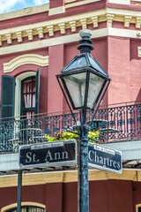 Street lamp with st. Ann and Chartres signs in background of building