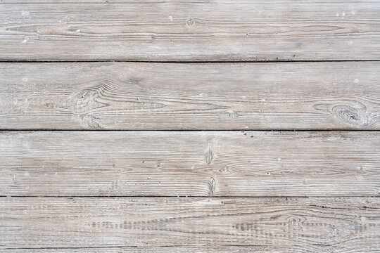Old wooden boards are painted with white paint while preserving the texture of wood