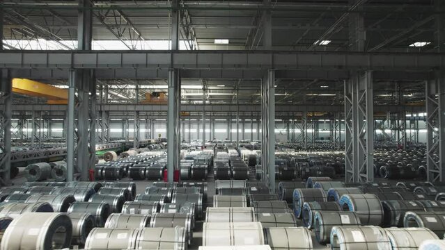 Industrial warehouse of a metallurgical enterprise. Rolled metal products are stored in rows in a warehouse.