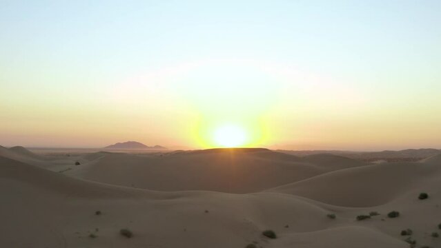 Sand dune sunrise panning into grand open sun rays. Aerial drone footage of sandy desert hills. Shot on DJI Mavic 2 Pro. Imperial Sand Dunes, California United States