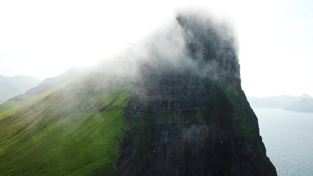 Aerial view of Kalsoy island, Faroe Islands. Amazing Faroese nature, green hills and beautiful rocky cliffs and mountains. Kallur lighthouse. Sunny day in summer. Movie Island in Faroe. 4k footage