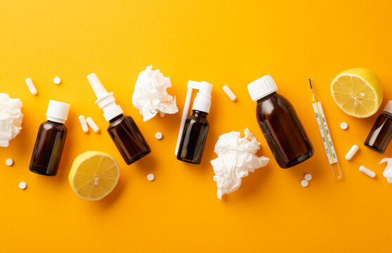 Seasonal diseases concept. Top view photo of remedy spray and syrup transparent brown bottles crumpled napkins tablets capsules thermometer and cut lemon on isolated orange background