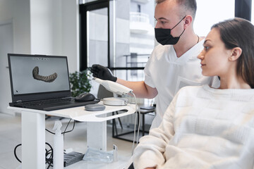 Obraz premium Male doctor and female patient discussing treatment in front of laptop screen