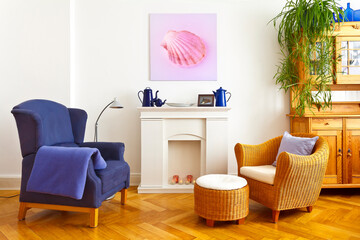 Custom-made home decoration concept: living room with a wing and a wicker chair, and a square canvas print of a pink shell picture.