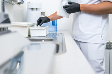 Male stomatologist wearing protective gloves preparing to the patient at his clean office