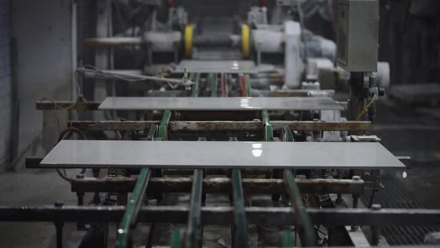Factory for the production of ceramic tiles and porcelain tiles. Automatic conveyor in the workshop.