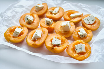 Apricots or peaches baked with blue cheese and lavender sprigs. Delicious dessert with fruits and cheese.Light background, banner, catering menu recipe, place for text. Sweet dessert with fruits 