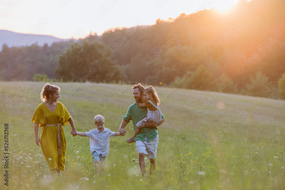 Wall mural Happy young family spending time together outside in green nature.