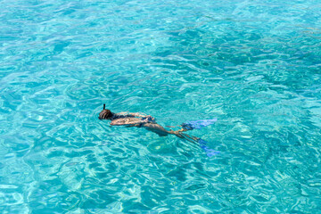 Girl snorkelling as she swims in clear tropical water during a vacation © tommoh29