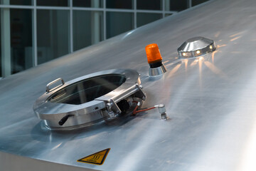 Pressure glass manhole on steel vessel for wort boiling at beer factory. Brewery equipment,...