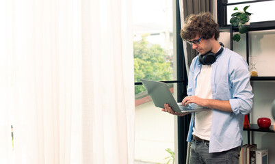 Young Caucasian Man work from home on laptop and connect online to office indoor for remote internet workplace. Young Adult male  is freelance work smart on notebook sit in working room, copy space