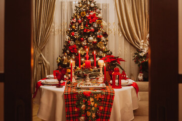 Entrance to the room with a festive table set against the background of a Christmas tree.