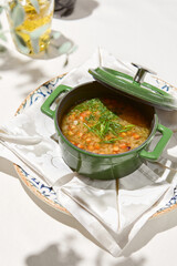 Composition with vegetable soup in ceramic pot. Minestrone soup with vegetables on summer day. Minestrone soup. Vegan menu. Hot dishes. Vegetables food. Eat less meat.