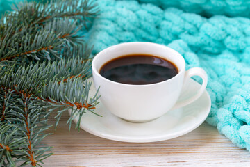 Obraz na płótnie Canvas A cup of coffee, a plaid, and a Christmas tree branch