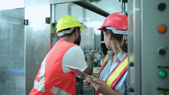 Female chief engineer of a mechanical plant Inspecting and explaining the maintenance of the machine to the mechanic. In order to check the working condition of the machine so that it is ready