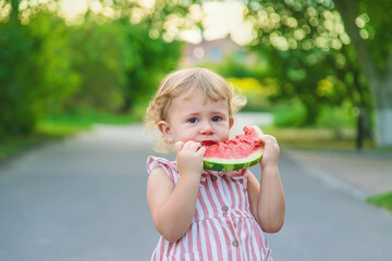 Naklejka premium Child girl eats watermelon in summer. Selective focus.