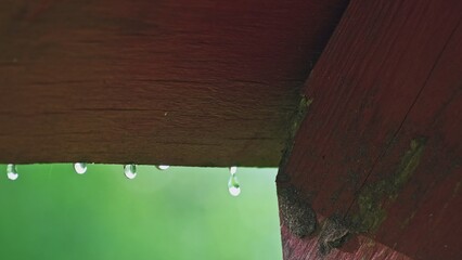 Rain Water Drops Dripping From Edge of Wooden Roof