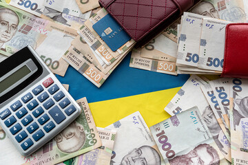 calculator with credit card on ukraine money in purse as financial background