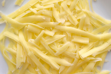 Grated cheese on a white plate. 