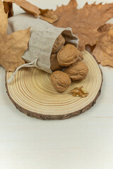 Fototapeta na wymiar nuts in sack and autumn leaves