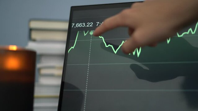 Close up touch screen computer analysing stock market with moving graph