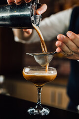 close up of barman preparing espresso martini cocktail