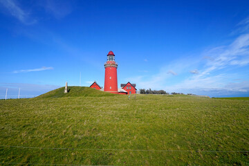 famous Bovbjerg Fyr lighthouse on the North Sea coast of Denmark in perfect light in front of a...